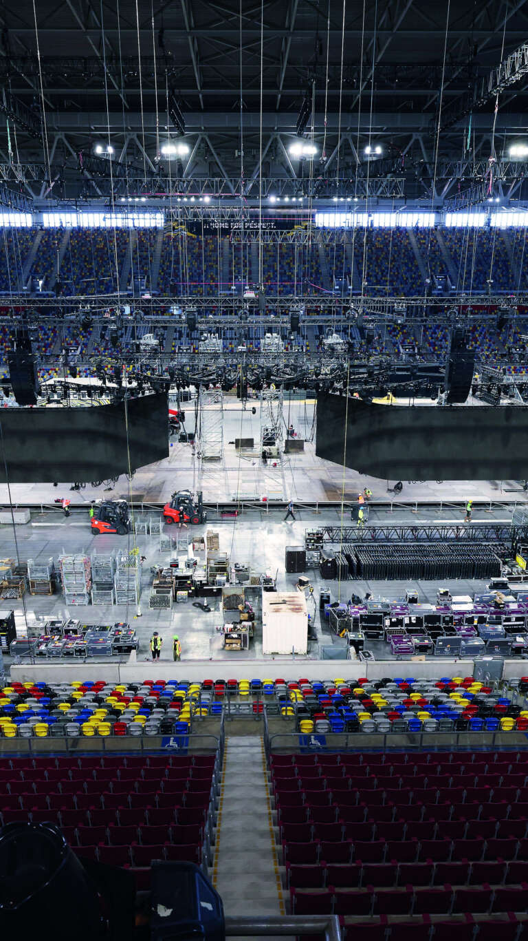 Vue des préparatifs techniques dans l'arène, illustrant l'ampleur logistique de l’événement.