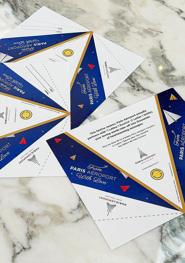 Foldable paper plane cards arranged on a marble table.