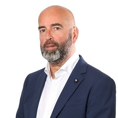 Professional portrait of Tom Declercq in a suit, on a white background.