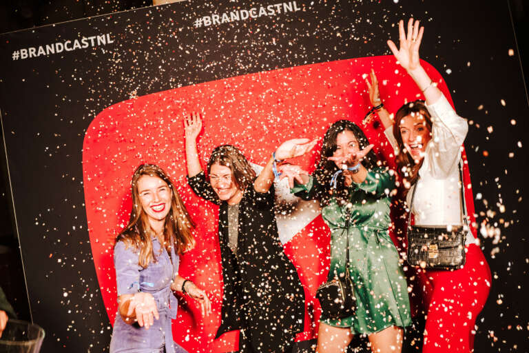 Festive brand activation at a YouTube booth, with confetti shower and enthusiastic participants