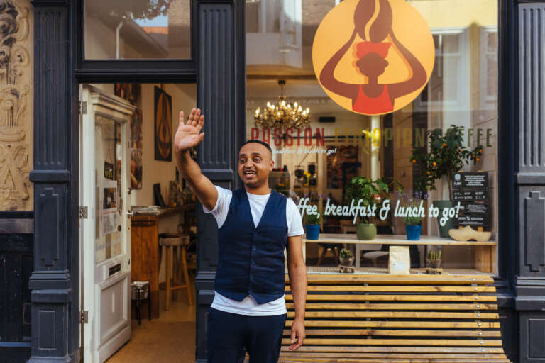 Un commerçant salue depuis l’entrée de son café éthiopien.