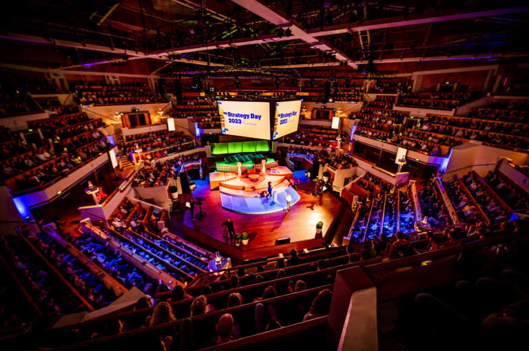 Corporate convention in an immersive venue with central stage and engaged audience