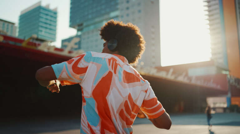 Young man dancing with headphones in the city, reflecting the agency’s creativity and energy