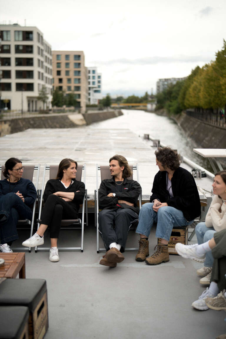 Échange informel entre collaborateurs OVAL dans un cadre naturel, incarnant la bienveillance au quotidien