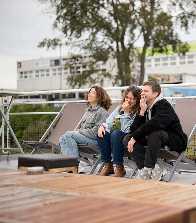 Three relaxed coworkers sharing a friendly moment outdoors