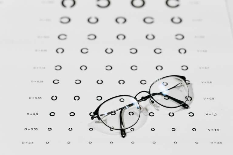 Glasses on a vision test chart, representing OVAL’s health insurance