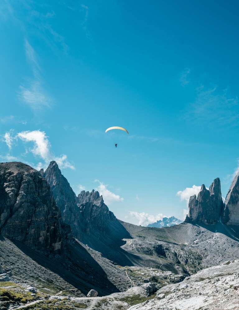 Paragliding in the mountains, representing the adventures OVAL offers for fidelity